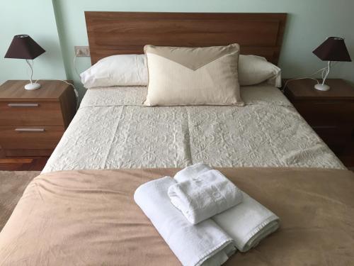 a bedroom with a bed with towels on it at PASEO DO MACEIRAS in Redondela