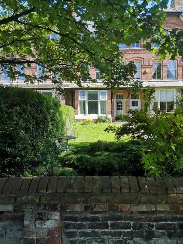 a brick house with a staircase in front of a yard at 34 One in Lytham St Annes
