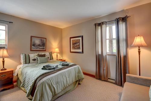 a bedroom with a bed and two lamps and a window at Jardin du Village by Chez Tremblant in Mont-Tremblant