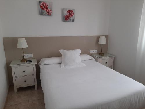 a bedroom with a large white bed with two night stands at Hotel La Terraza in Miño