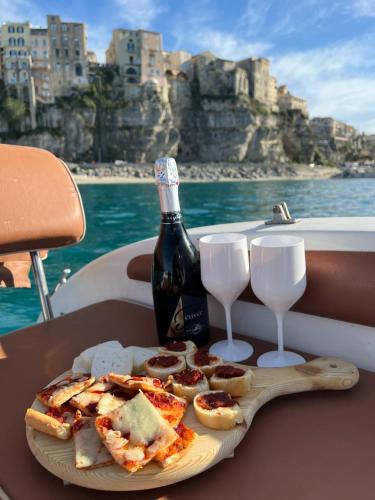 a plate of food and a bottle of wine and glasses at B&B Costa degli Dei in Tropea