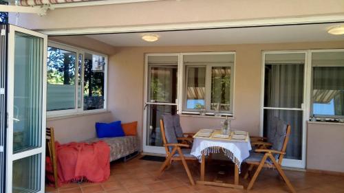 a room with a table and chairs and windows at Apartma Andrea in Medulin
