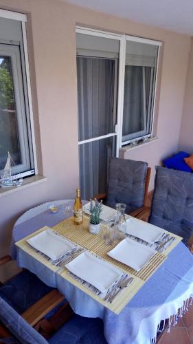 a table with a blue table cloth and two windows at Apartma Andrea in Medulin