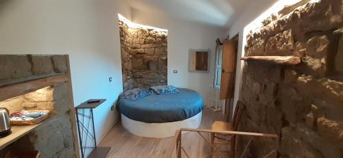 een kamer met een bed en een stenen muur bij Il Gelsomino in Castelmezzano
