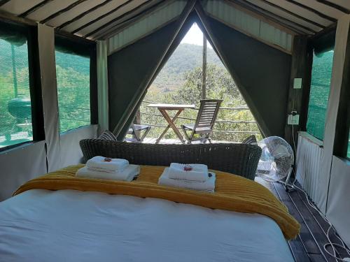 ein Bett in einem Zelt mit zwei Handtüchern darauf in der Unterkunft The Nest @ The Old Trading Post in Wilderness