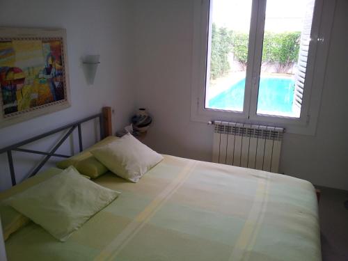 a bedroom with a bed and a window and a pool at Bahía 66 in Empuriabrava