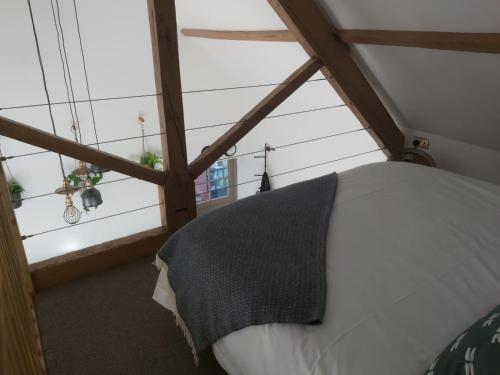 um quarto com uma cama branca num sótão em Sweet Meadow Lodge em Exeter