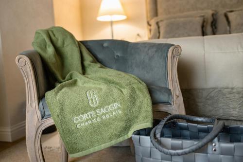 a green blanket sitting on a chair with a couch at CORTE SAGGIN Charme Relais in San Pietro in Cariano