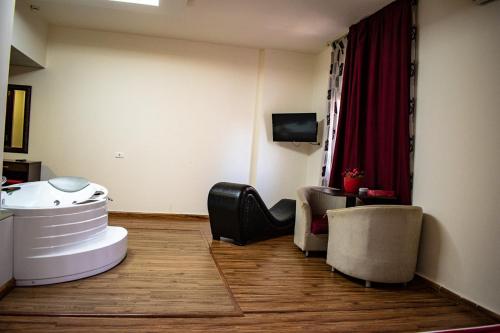 a living room with two chairs and a television at Al Murjan Palace Hotel Jounieh in Jounieh