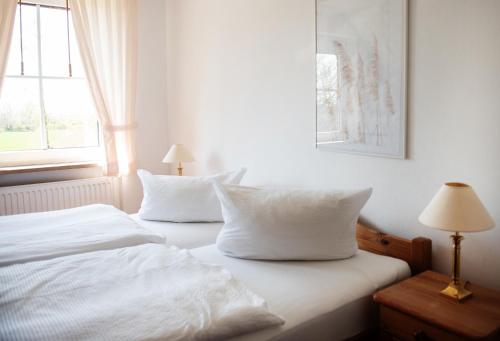 een slaapkamer met twee witte kussens op een bed bij Bauernhof Höper-Rauert - Reihenhaus 5 in Neujellingsdorf
