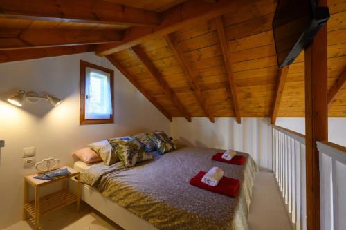 - une chambre avec un lit dans une pièce dotée de plafonds en bois dans l'établissement Villa Rosa, à Argyrádes