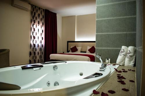 a bathroom with a bath tub and a bed at Al Murjan Palace Hotel Jounieh in Jounieh