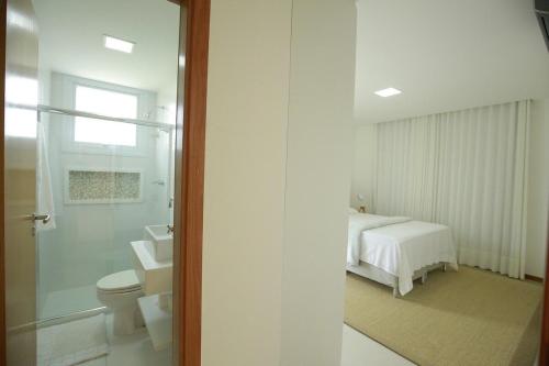 カマサリにあるCasa Luxo Temporada - 5 quartos - Guarajuba - Academia - Piscina e Vistaのバスルーム(ベッド1台、トイレ、シンク付)