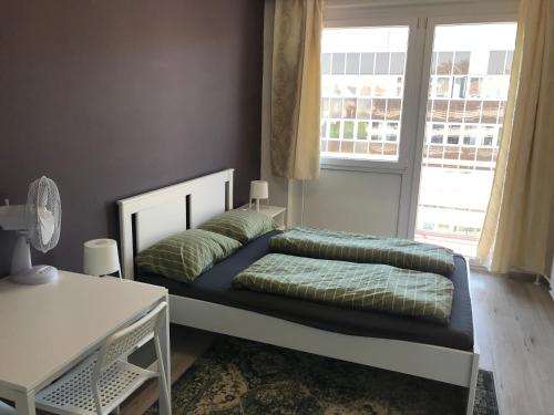 a bed in a room with a large window at Roland apartment WestND in Budapest