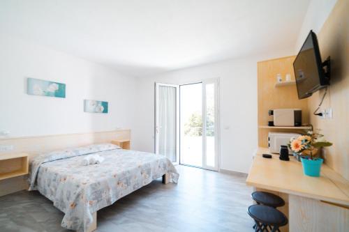 a bedroom with a bed and a television in it at Agriturismo b&b Mares e Montes de Marrante in Siniscola