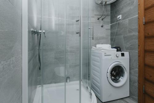 y baño con cabina de ducha y lavadora. en Apartments Bella Rosa, en Budva