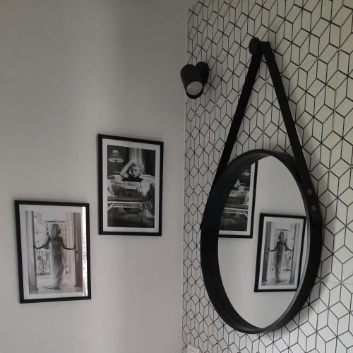 a mirror hanging on a wall with pictures at Domki Dobrogoszcz in Dobrogoszcz