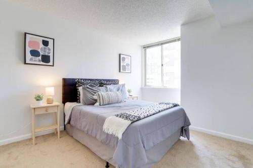 a white bedroom with a bed and a window at Bright Apartment Walk to Ballston Metro in Arlington