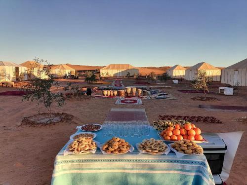 a table with food on it in the desert at Merzouga Camp & Desert Activities in Merzouga
