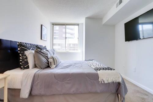 a bedroom with a large bed with a window at Exquisite 1 Bedroom Condo At Ballston With Gym in Arlington