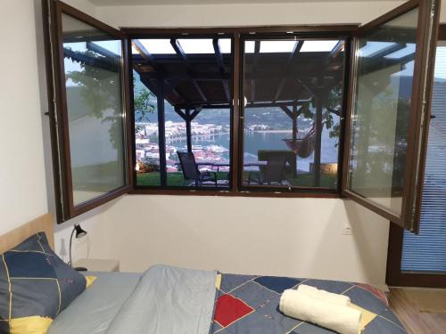 a bedroom with a large window with a view of the water at Snegar Apartments in Ohrid