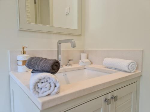 bagno con lavandino, asciugamani e specchio di Porto Montenegro Luxury Studio Zeta a Tivat