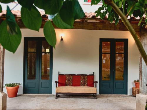 a bench in front of a house with blue doors at Épicos House, Your home away from home. in Nogueira