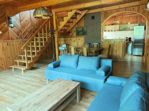 salon z niebieską kanapą i schodami w obiekcie Dom Wakacyjny z ogromnym ogrodem w mieście Witaszyn