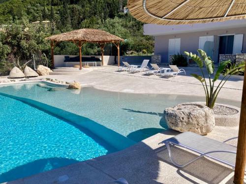a large swimming pool with chairs and a umbrella at Ninfas del Mar in Agios Nikitas