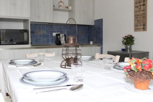 a table with a white table cloth and plates and a lantern at Art Apartment Chianti Family in Lappeggi