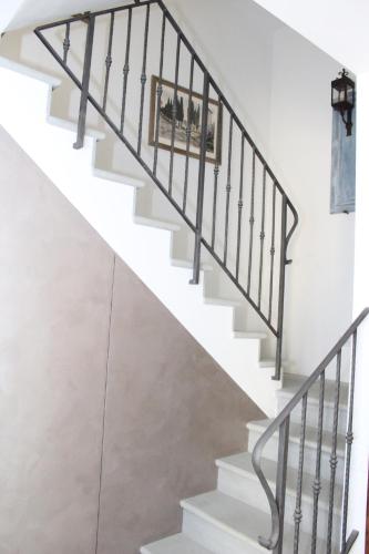 a staircase with white stairs and black railings at Art Apartment Chianti Family in Lappeggi