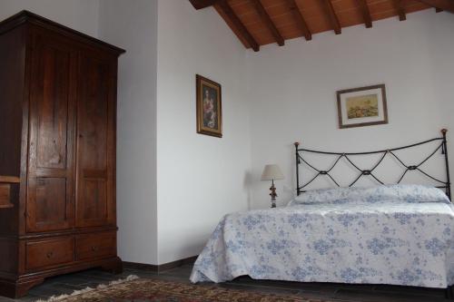 a bedroom with a bed and a wooden cabinet at Art Apartment Chianti Family in Lappeggi