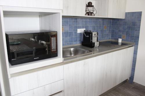 a kitchen with a sink and a microwave at Art Apartment Chianti Family in Lappeggi
