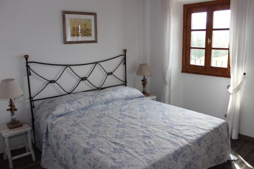 a bedroom with a bed with a blue comforter and a window at Art Apartment Chianti Family in Lappeggi