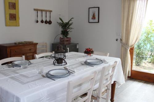 a white table with white chairs and a white table cloth at Art Apartment Chianti Family in Lappeggi