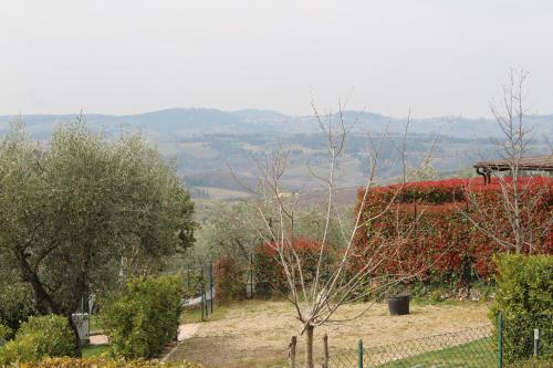 a view of a garden with trees and a fence at Art Apartment Chianti Family in Lappeggi