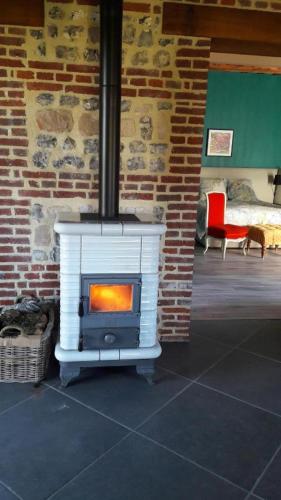 a stove in a room with a brick wall at DOMAINE DE JANVILLE in Paluel