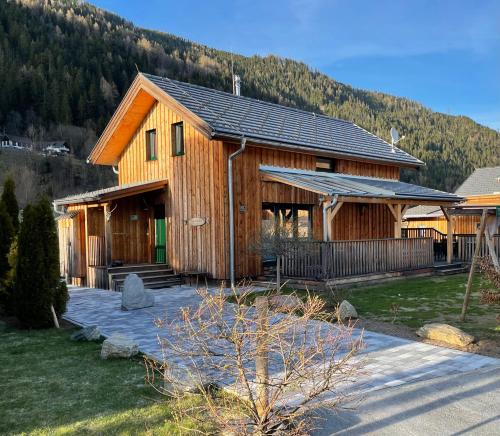 a large wooden house with a mountain in the background at Chalet Steiermark in Murau