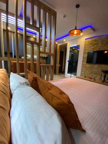a bedroom with a bed with pillows and a tv at PleasureLUX MILMARI in Kopaonik