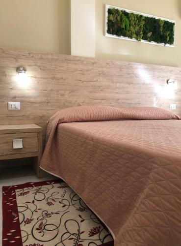 - une chambre avec un lit et un mur en bois dans l'établissement Hotel Centrale, à Quartu SantʼElena