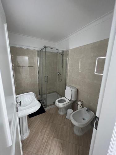 a bathroom with a toilet and a shower and a sink at Relaxing 2 Bedroom House 5 minutes away from Vilamoura Marina in Quarteira