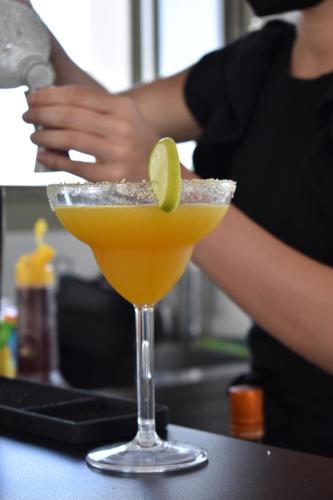 a woman is making a drink in a glass at Kallos Imar Boutique Hotel in Mesaria