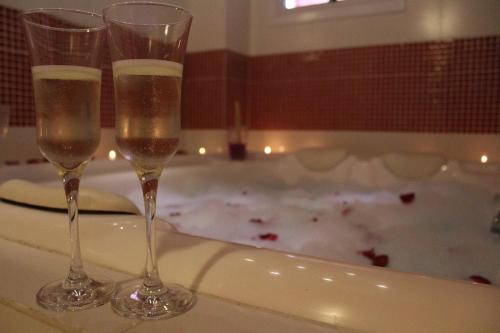 two glasses of champagne sitting on a bath tub at Amber 449 in Gramado