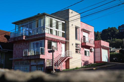 a tall brick building with a balcony on a street at Amber 449 in Gramado