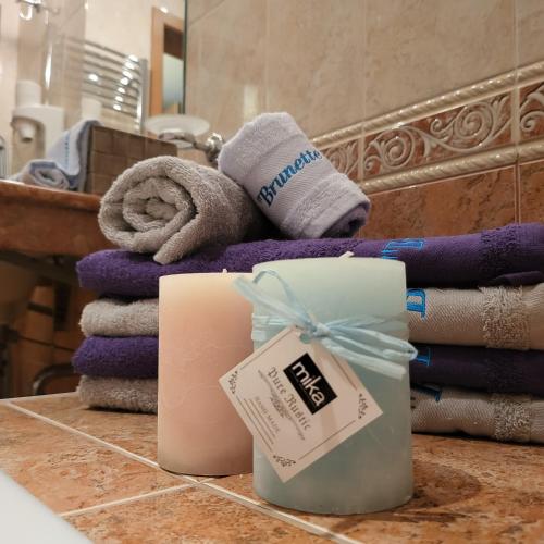 a pile of towels on a counter in a bathroom at "Красавиците тъмнокоси" Sunset Resort Pomorie in Pomorie