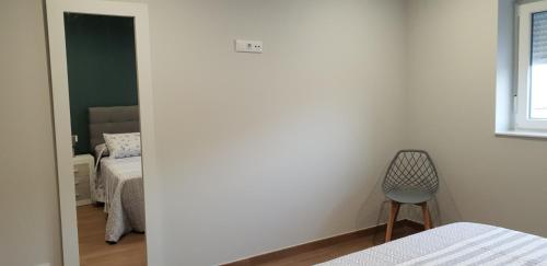 a room with two beds and a chair in it at A Solaina in Lariño