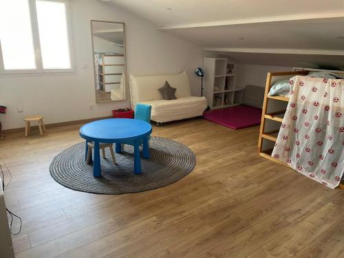 - un salon avec une table bleue et un lit dans l'établissement Villa calme piscine proche mer petite salle cinéma, à Montagnac