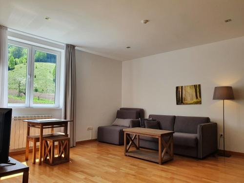 a living room with a couch and a table at PLANINSKO JUTRO - Brzeće Centar Apartments, Kopaonik in Brzeće