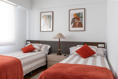 1 Schlafzimmer mit 2 Betten und einem Sofa in der Unterkunft Luminoso apartamento en Cuatro Caminos in A Coruña