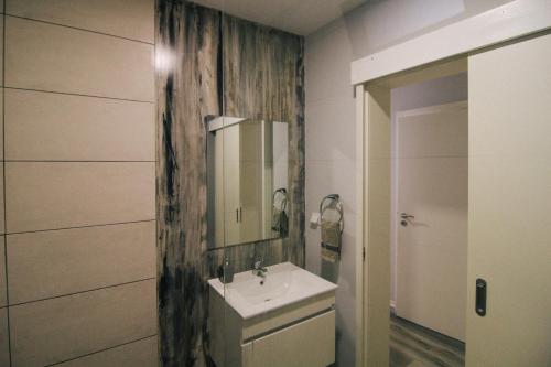 un bagno con lavandino e specchio di Casa do Brasileiro ad Arco da Calheta